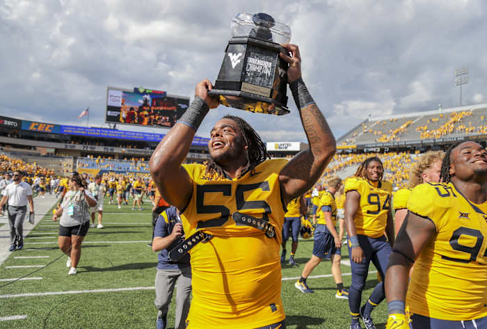 Sep 18, 2021; Morgantown, West Virginia, USA; West Virginia Mountaineers defensive lineman Dante Stills (55) celebrates with the Black Diamond Trophy after defeating the Virginia Tech Hokies at Mountaineer Field at Milan Puskar Stadium.